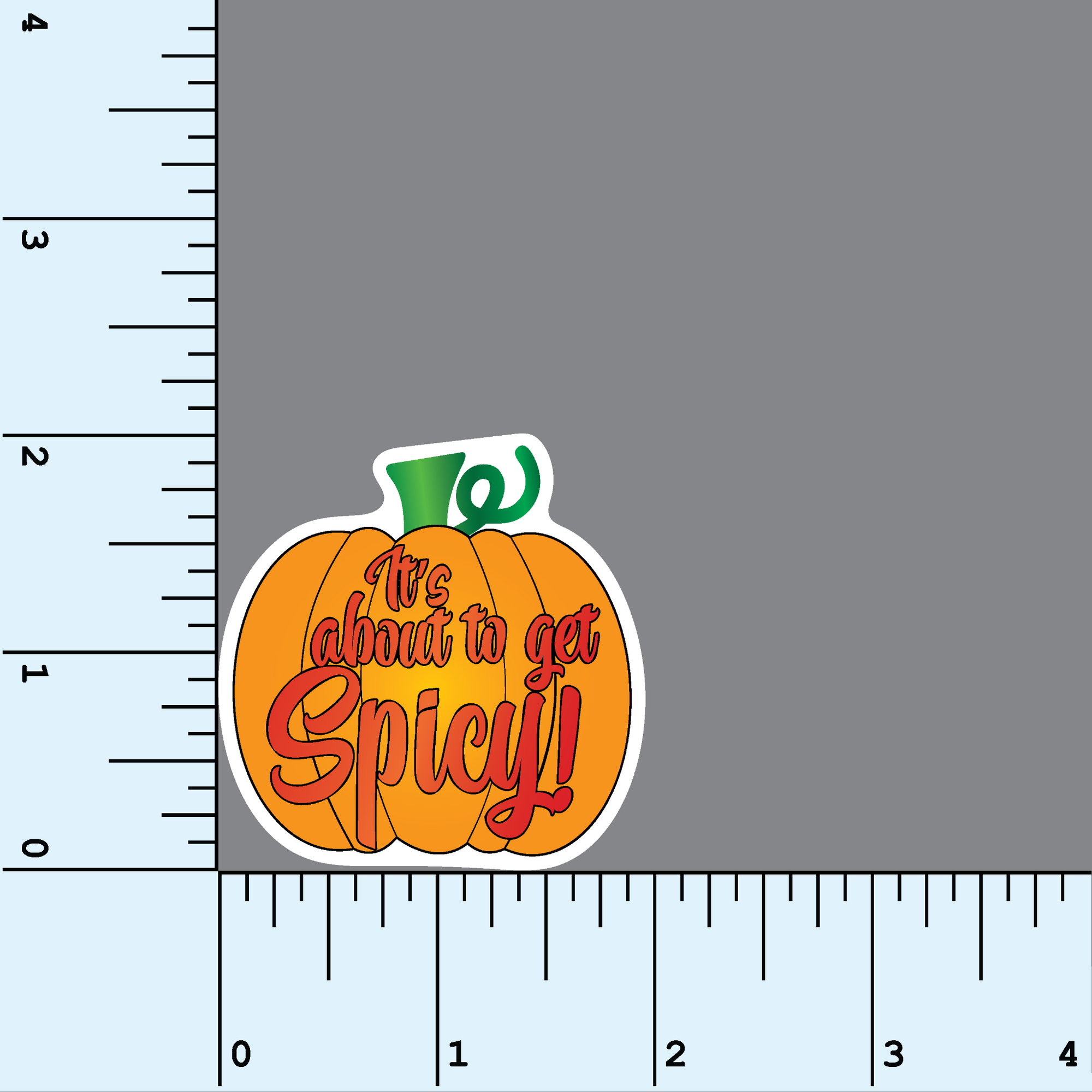 An orange and green colored pumpkin shaped sticker with the red text &quot;it&#39;s about to get spicy!&quot; on a background with measurements to show the sticker is 2&quot; in size.