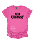 A pink shirt with the text "NOT FRIENDLY the dog is also sketchy af" printed in black.