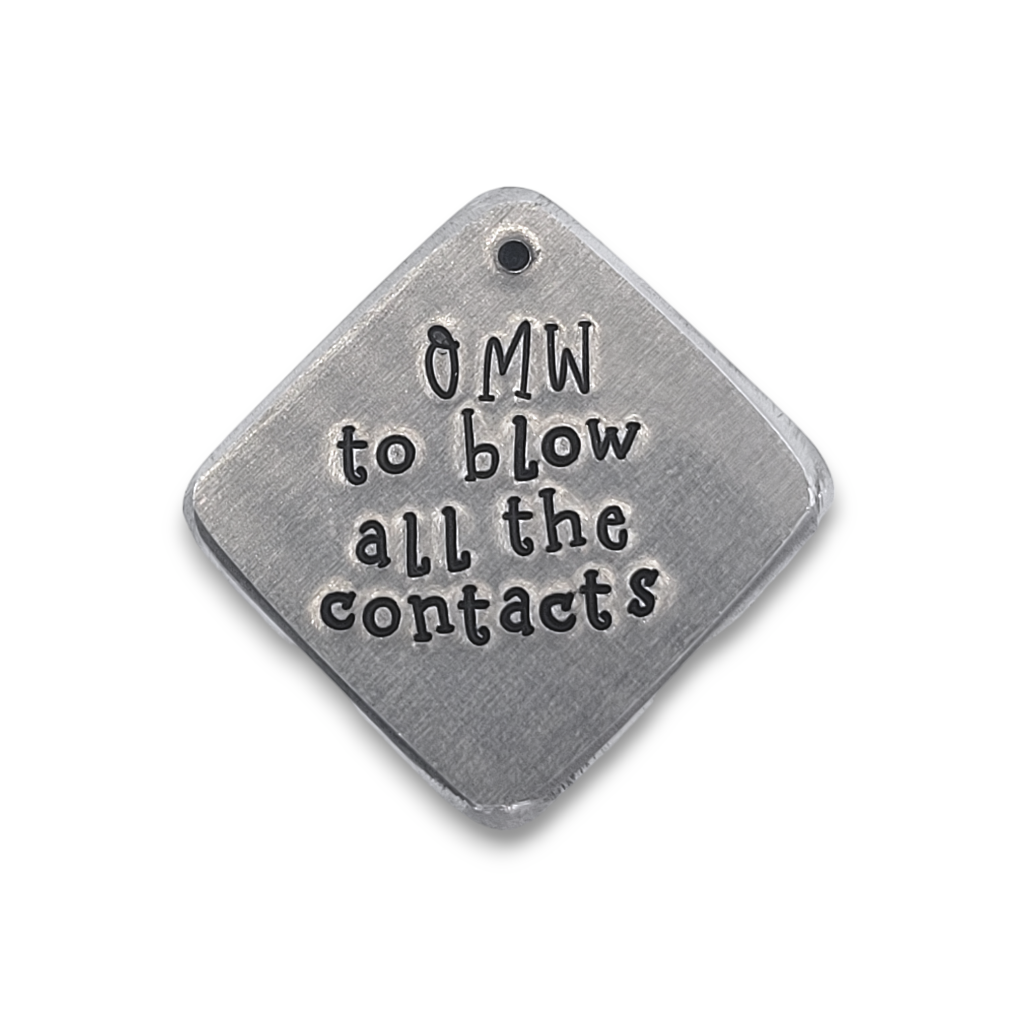 A diamond shaped silver toned metal tag with &quot;OMW to blow all the contacts&quot; in black lettering.